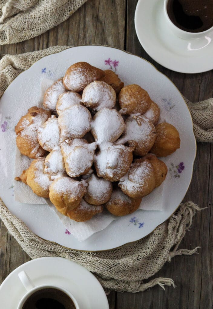 Ustipci sprinkled with powdered sugar and served with coffee.
